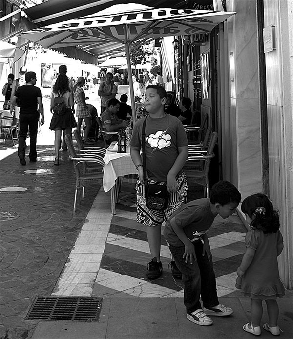 children playing by coffee shops in Malaga, Spain
