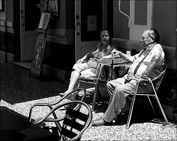 Old couple enjoying the shade outside a coffee shop in Malaga